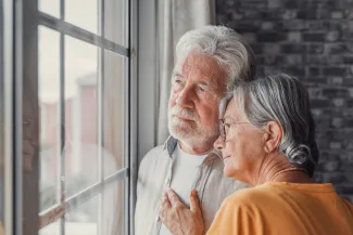 Old woman wife consoling and hugging sad husband